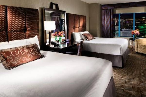 Zwei Doppelbetten im Hotelzimmer des New York-New York Hotel & Casino mit Stadtblick.