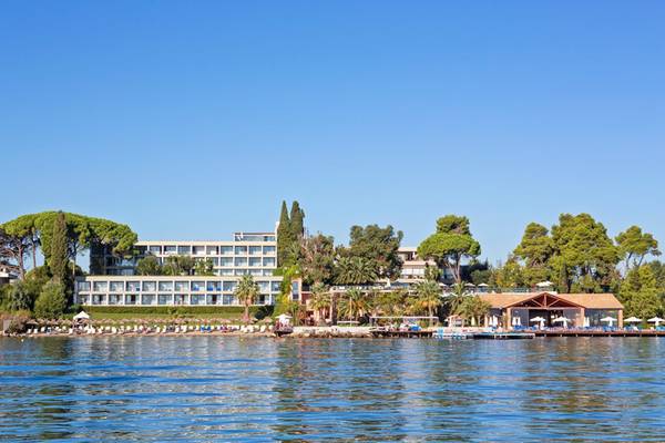 Außenansicht des Kontokali Bay Resort & Spa mit vielen Bäumen und einer Bucht im Hintergrund.