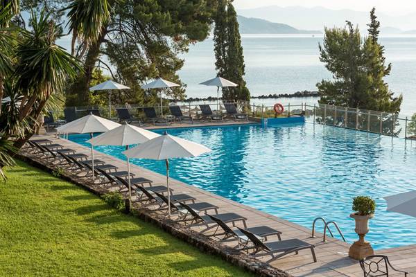 Außenpool des Kontokali Bay Resort & Spa mit Sonnenliegen und Schirmen.
