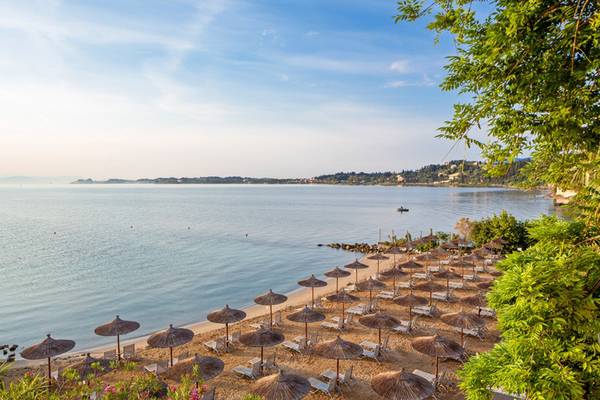 Luftaufnahme des Kontokali Bay Resorts & Spa mit vielen Sonnenschirmen am Strand