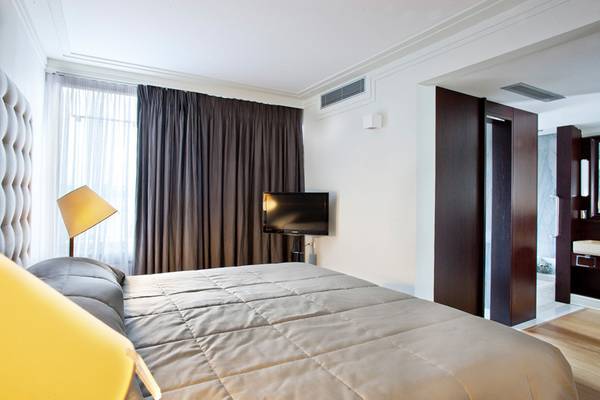 Schlafzimmer im Kontokali Bay Resort & Spa mit einem Bett, Fernseher, und Lampen.