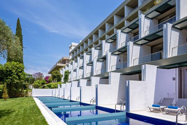 Außenbereich des Kontokali Bay Resort & Spa mit Swimmingpool und Liegestühlen