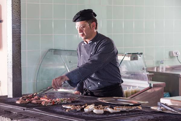 Koch grillt auf einem Grill im Kontokali Bay Resort & Spa Hotel.