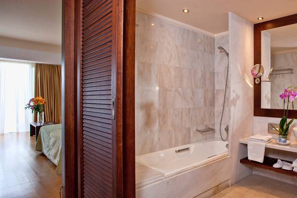 Badezimmer im Kontokali Bay Resort & Spa mit Badewanne, Dusche und Spiegel.