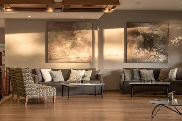 Lobby des Kontokali Bay Resort & Spa mit Sofas, Tischen und Gemälden an der Wand.