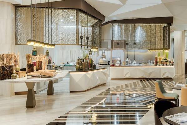 Innenansicht des Restaurants im Kempinski Hotel Muscat mit moderner Einrichtung, Tischen und Stühlen.