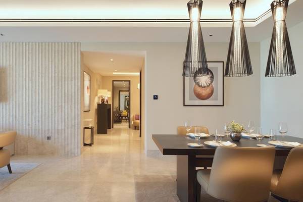 Innenraum des Kempinski Hotel Muscat mit Esstisch, Stühlen und Fernseher an der Wand.