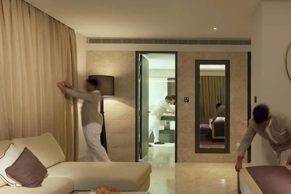 Zimmerservice im Kempinski Hotel Muscat, zwei Angestellte servieren das Bett und den Tisch.