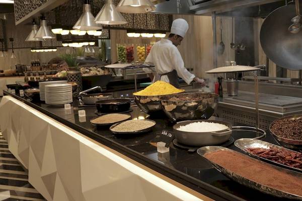 Buffet im Kempinski Hotel Muscat mit verschiedenen Speisen in Schalen auf einem schwarzen Tisch.