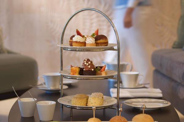 Empfangsbereich des Kempinski Hotels Muscat mit einer Auswahl an Desserts auf einem dreistöckigen Serviertablett.