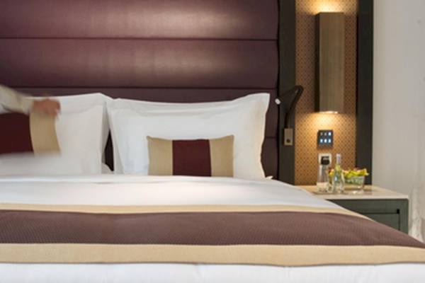 Ein Mitarbeiter des Kempinski Hotel Muscat macht das Bett in einem Gästezimmer.