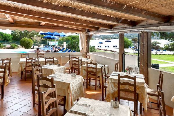 Innenansicht des Restaurants im Colonna Hotel Du Golf mit Tischen und Stühlen, Blick auf den Pool und die Terrasse.