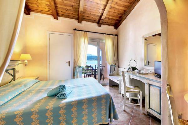 Colonna Hotel Du Golf Schlafzimmer mit Balkon, Bett, Schreibtisch und Meerblick.