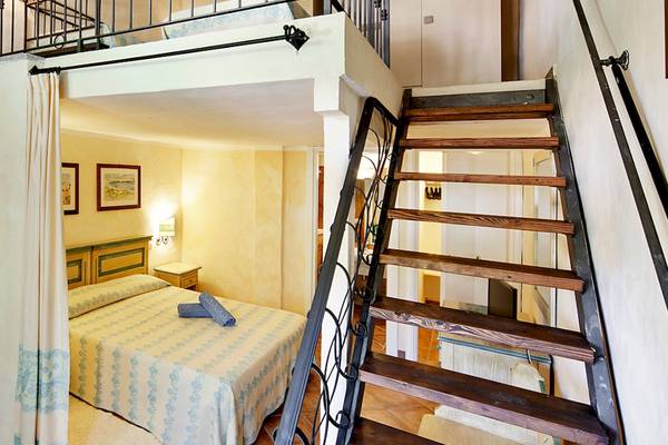 Doppelbett-Zimmer mit Aufzug im Hotel Colonna Du Golf mit hellem Dekor, Holztreppe und Balkon.