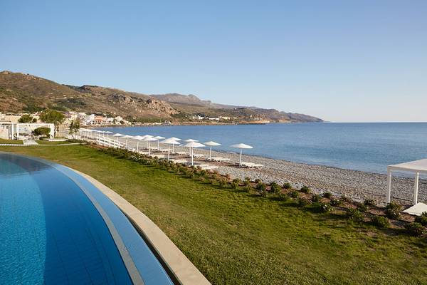 Aussicht auf den Strand des Giannoulis Grand Bay Beach Resorts mit Swimmingpool und Sonnenschirmen