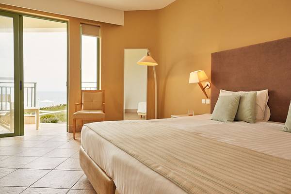 Innenansicht eines Zimmers im Giannoulis Grand Bay Beach Resort mit Blick auf das Meer.