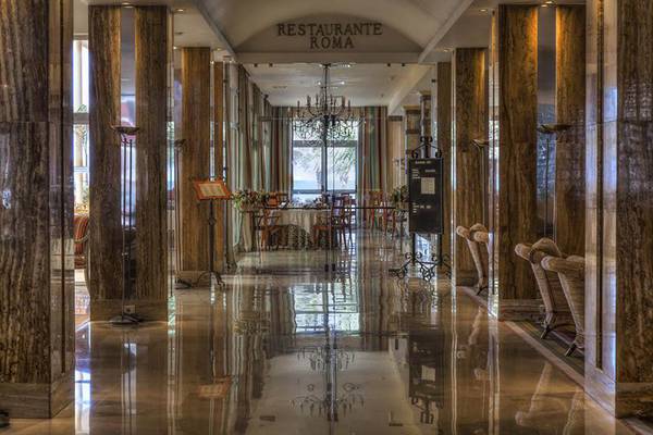 Foto des Restaurants Roma im Bull Hotel Reina Isabel mit marmornen Säulen und reflektierter Decke.