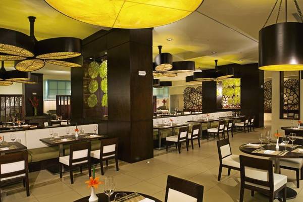 Innenbereich des Restaurants im Dreams Las Mareas Costa Rica Hotel mit modernen Möbeln und Tischdekoration.
