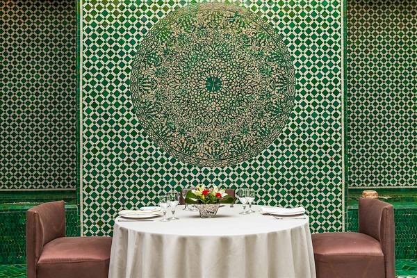 Foto von einem Tisch im Allegro Agadir Hotel mit grünen Wänden und einem Blumenarrangement.