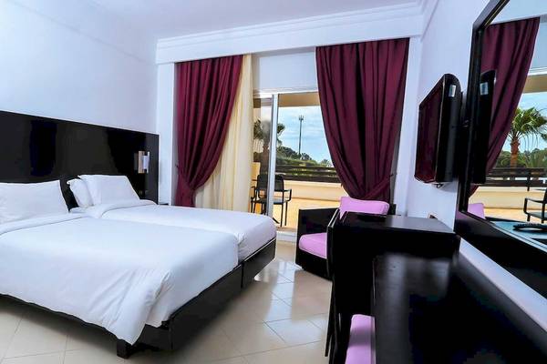 Doppelzimmer im Allegro Agadir Hotel mit zwei Betten, Fernseher und Balkon.