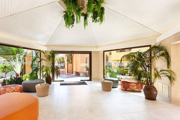 Der Eingangsbereich des Tagoro Family & Fun Costa Adeje Hotels mit Innendekoration, Pflanzen und Möbeln.