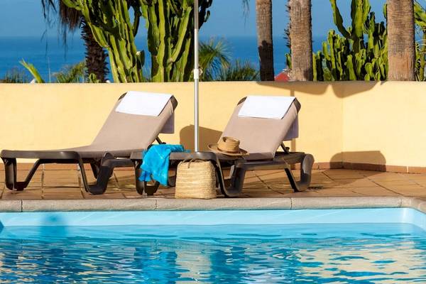 Zwei Liegestühle neben einem Pool im Tagoro Family & Fun Costa Adeje Hotel