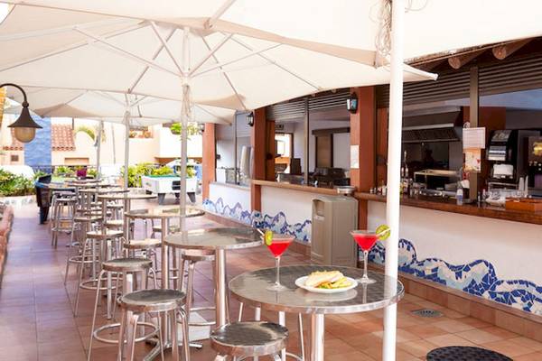 Hotelbar des Tagoro Family & Fun Costa Adeje mit Tischen und Cocktails.
