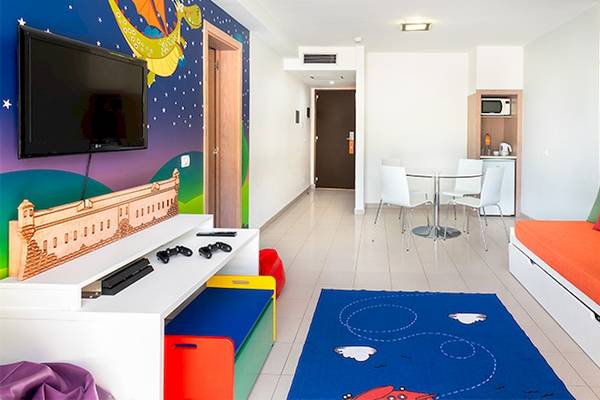 Kinderzimmer im Tagoro Family & Fun Costa Adeje mit bunten Wänden, Fernseher und Spielkonsolen.