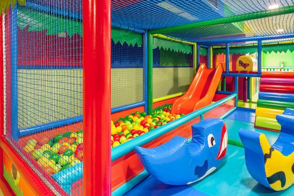 Kinderspielplatz im Tagoro Family & Fun Costa Adeje mit bunten Spielgeräten und einer Rutsche.