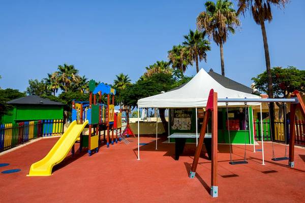 Spielplatz im Hotel Tagoro Family & Fun Costa Adeje mit Rutsche, Schaukeln und Zelt.
