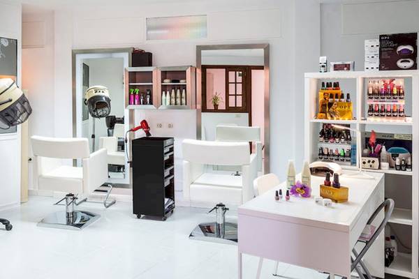 Friseursalon im Hotel Tagoro Family & Fun Costa Adeje mit weißen Stühlen und Geräten.