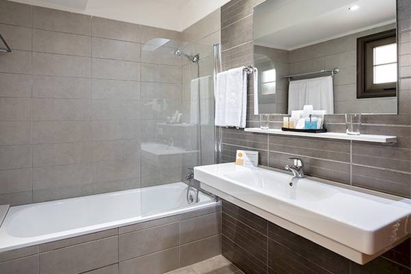 Badezimmer im Tagoro Family & Fun Hotel in Costa Adeje mit Badewanne, Dusche, Waschbecken und Toilette.