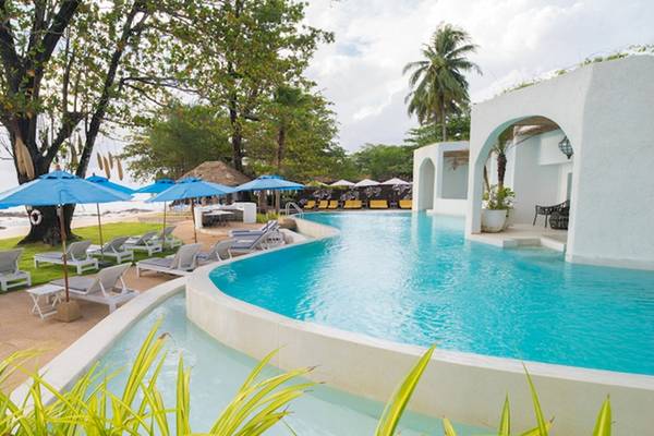 Außenpool des Ocean Breeze Resort Khao Lak mit Sonnenliegen und blauen Sonnenschirmen