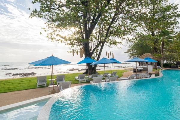 Außenpool des Ocean Breeze Resort Khao Lak mit Sonnenliegen und Sonnenschirmen am Meer