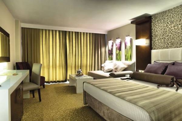 Hotelzimmer im Tusan Beach Resort mit Bett, Sofa, Schreibtisch und Stühlen.