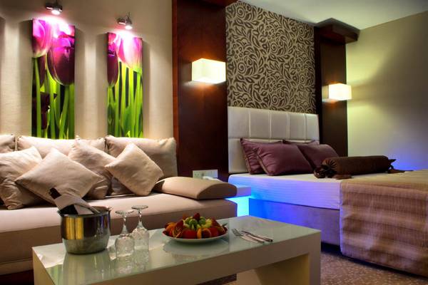 Suite-Innenraum im Tusan Beach Resort mit Möbeln, Bett und Wandbildern.