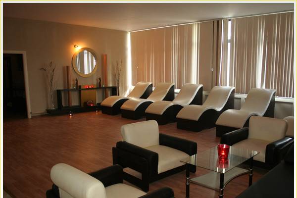 Loungebereich im Tusan Beach Resort mit weißen Sesseln und einer Glastisch.