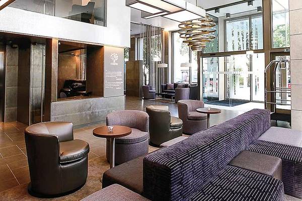 Lobby des Neya Lisboa Hotels mit modernen Möbeln und leuchtenden Lampen.