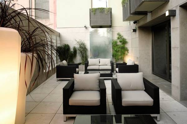 Foto von der Terrasse des Neya Lisboa Hotels mit Sitzecken und Pflanzen.
