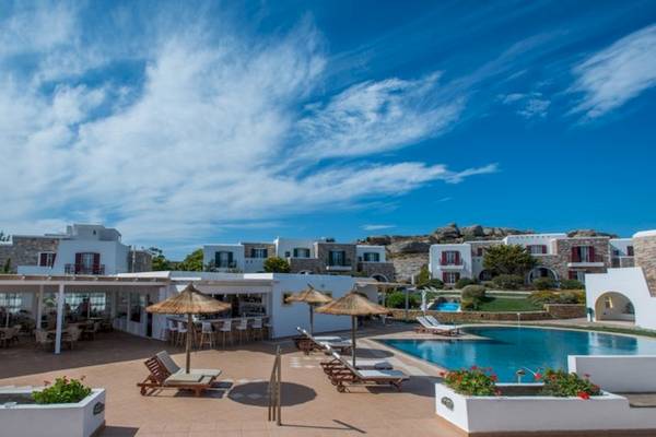Außenbereich des Naxos Palace Hotels mit Pool, Liegestühlen und Schirmen.