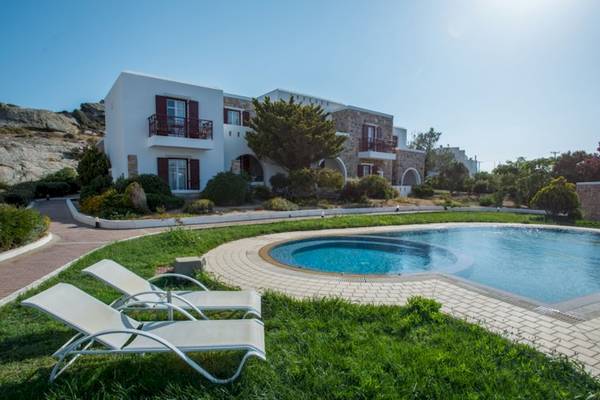 Das Naxos Palace Hotel mit einem Pool und Liegen auf dem Rasen.