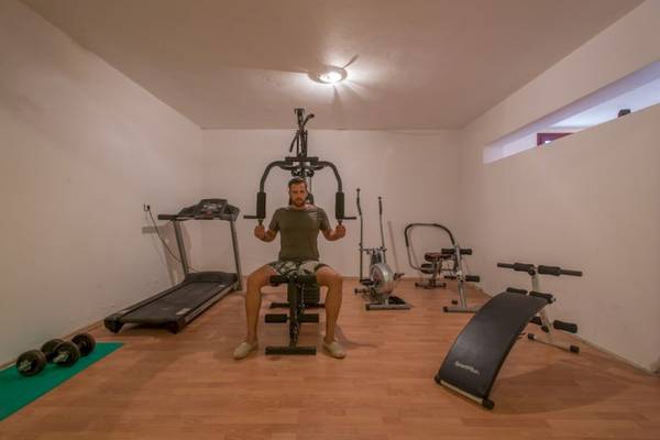 Fitnessraum im Naxos Palast Hotel mit einem Mann, der ein Liegestützgerät benutzt.