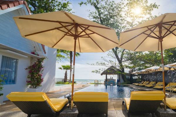 Poolseite des Ocean Breeze Resort Khao Lak mit gelben Lounge-Sesseln unter Sonnenschirmen