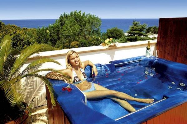 Frau im Whirlpool mit Meerblick im Aldiana Club Rocca Nettuno Calabria