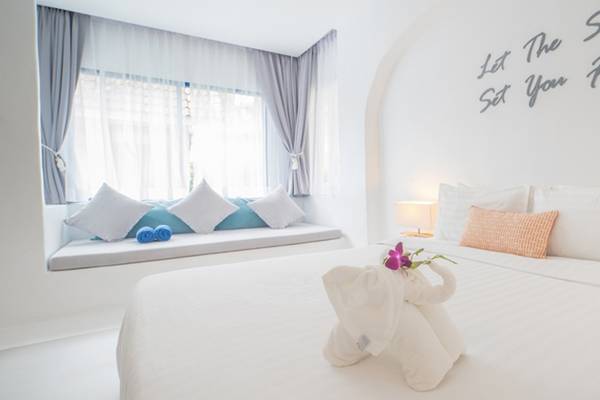 Schlafzimmer im Ocean Breeze Resort Khao Lak mit einem Bett, einem Fenster und einer Bank