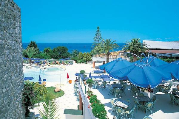 Aussicht auf das Aldiana Club Rocca Nettuno Hotel mit Pool und Meerblick.