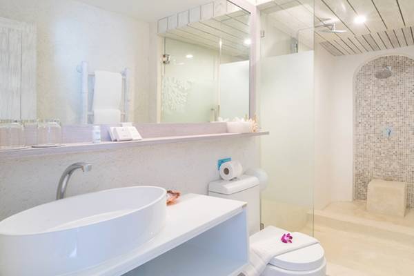 Badezimmer im Ocean Breeze Resort Khao Lak mit Dusche, Toilette, Waschbecken und Spiegel.