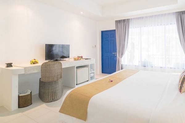 Hotelzimmer im Ocean Breeze Resort Khao Lak mit einem Bett, Schreibtisch und Fernseher.