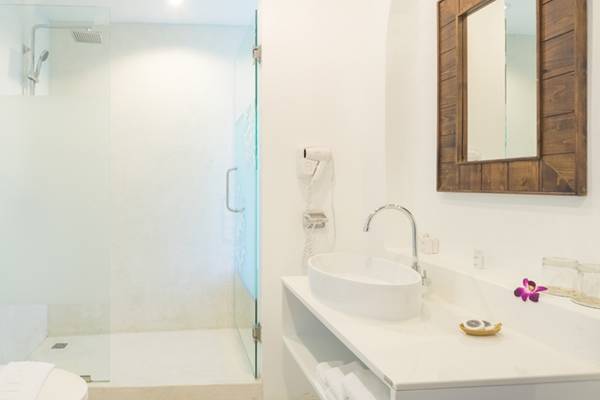 Badezimmer im Ocean Breeze Resort Khao Lak mit Dusche, Toilette und Waschbecken.