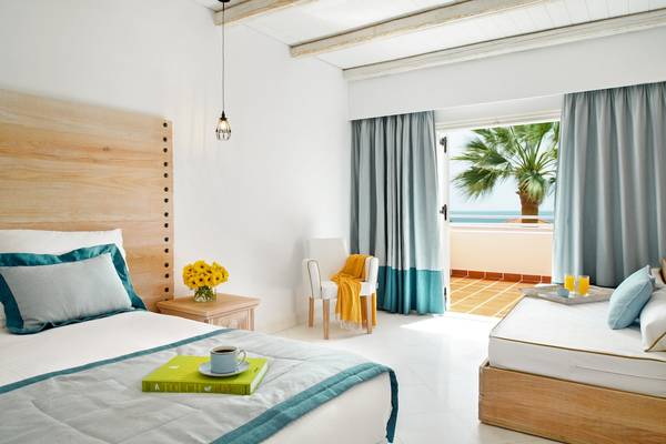 Zimmer im Mitsis Rodos Village Beach Hotel mit Blick auf das Meer und einer offenen Terrasse.